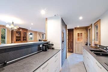 A kitchen with white cabinets and black counter tops
