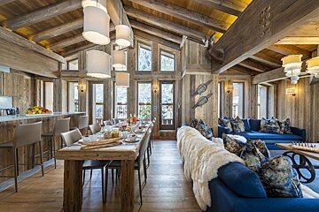 A living room with a blue couch and a wooden table