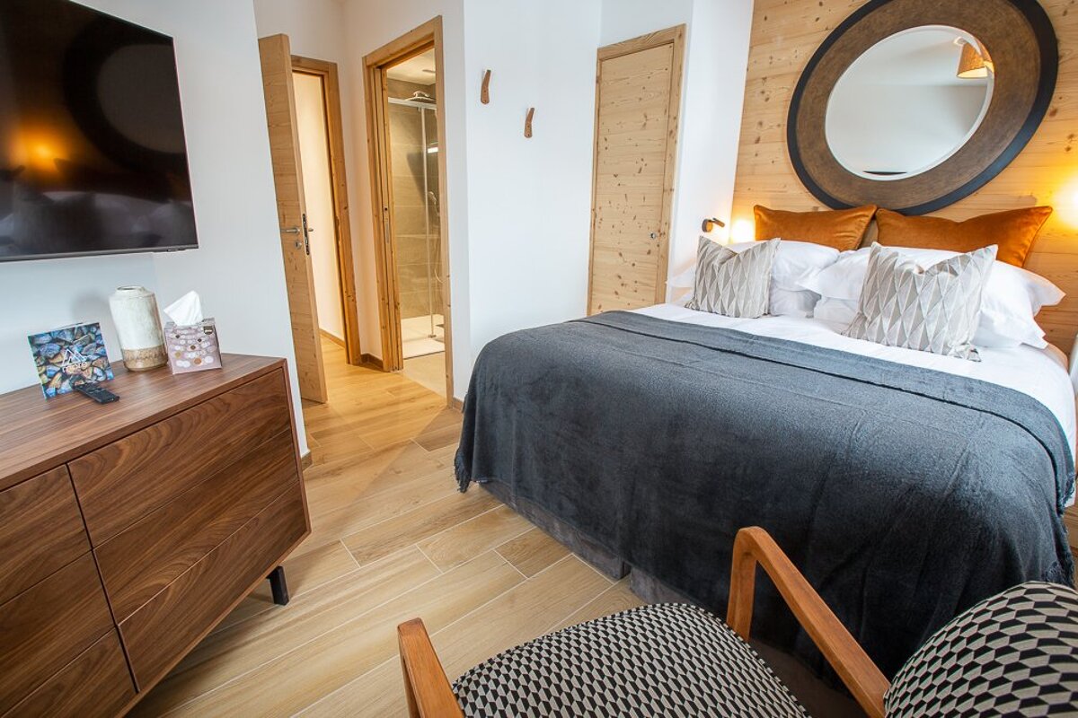 A bedroom with a large bed and a large mirror