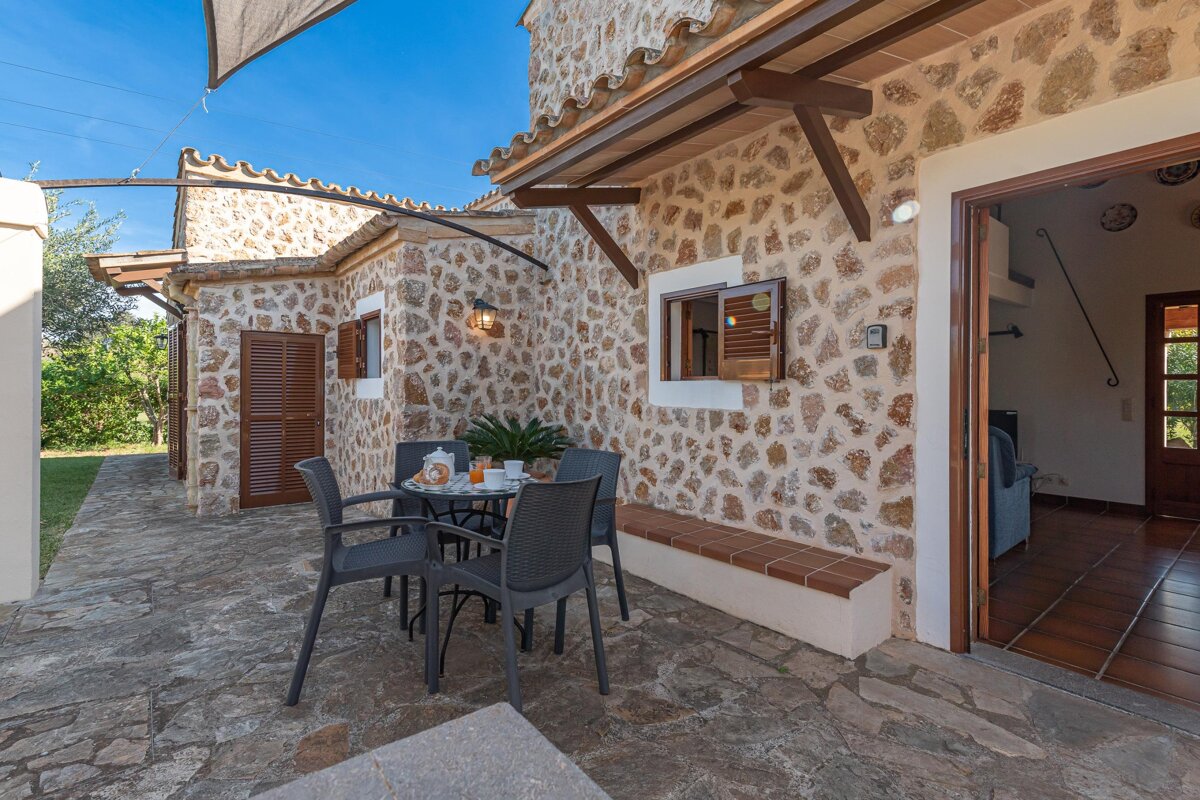 A stone building with a table and chairs outside