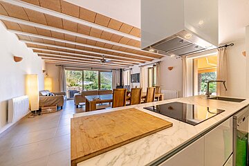 A kitchen with a wooden cutting board on the counter