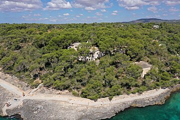 An aerial view of a house in the middle of a forest