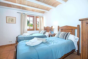 A bedroom with two beds and a picture on the wall
