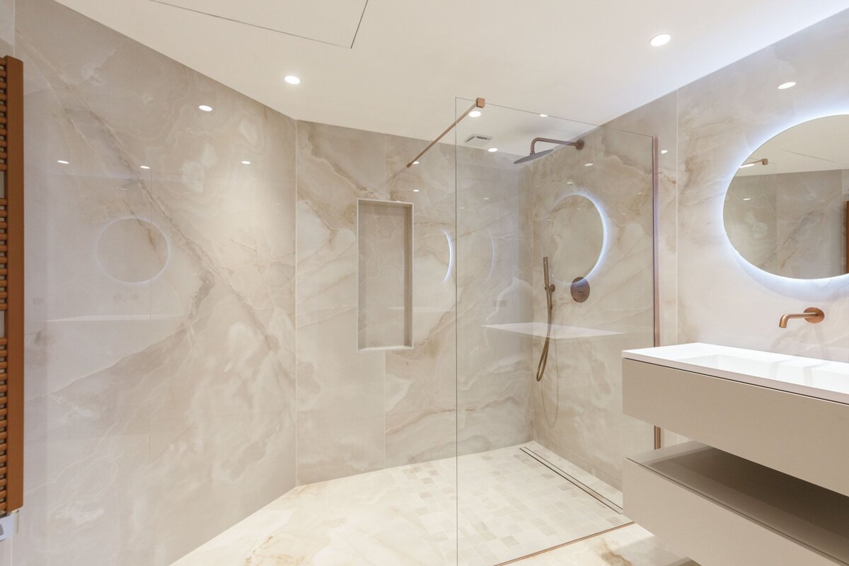 A bathroom with a walk in shower and a sink