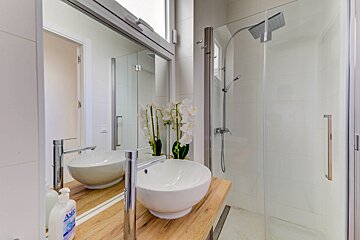 A bathroom with two sinks and a bottle of axis soap