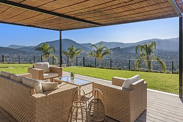 A patio with wicker furniture and a view of mountains