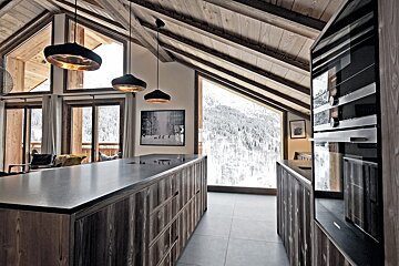 A kitchen with a large island and a large window