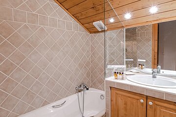 A bathroom with a bathtub a sink and a mirror