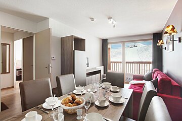 A dining table with a basket of bread on it