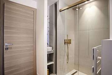 A bathroom with a sliding glass shower door