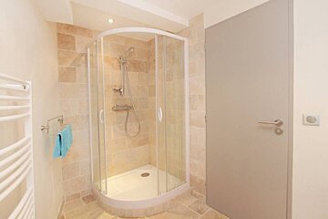 A bathroom with a shower stall and a door