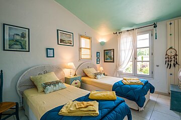 A bedroom with two beds and a dream catcher on the wall