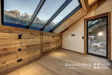 A room with wooden walls and a skylight from mountain base