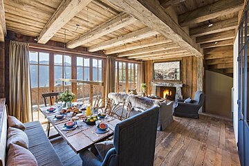 A living room with a table and chairs and a fireplace