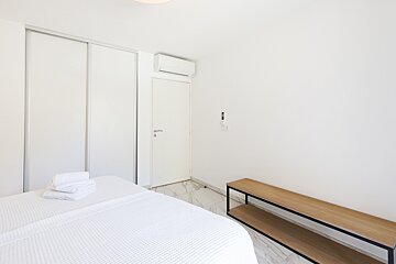 A bedroom with white walls and a white door