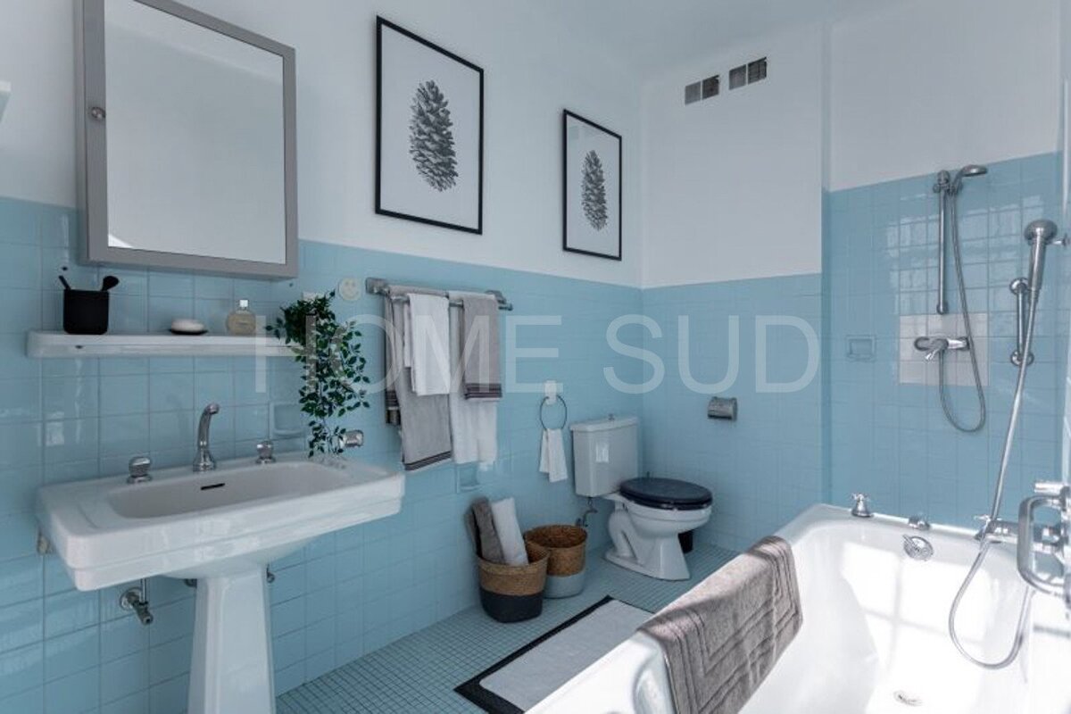 A bathroom with blue tiles and the words home sud on the wall