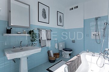 A bathroom with blue tiles and the words home sud on the wall