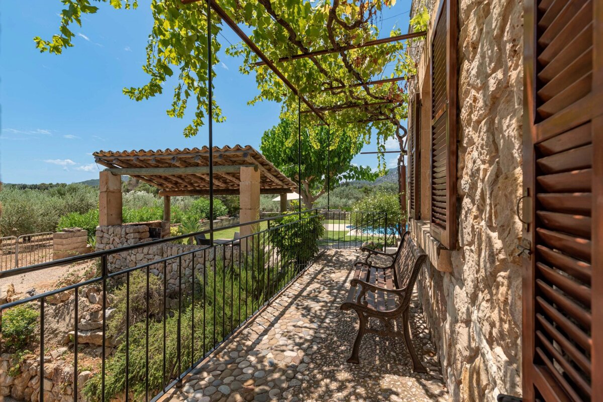 A stone building with a fence and a bench in front of it