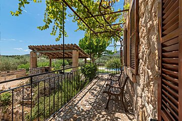A stone building with a fence and a bench in front of it