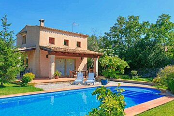 A house with a large swimming pool in front of it
