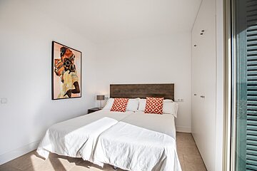 A bedroom with a bed and a painting on the wall