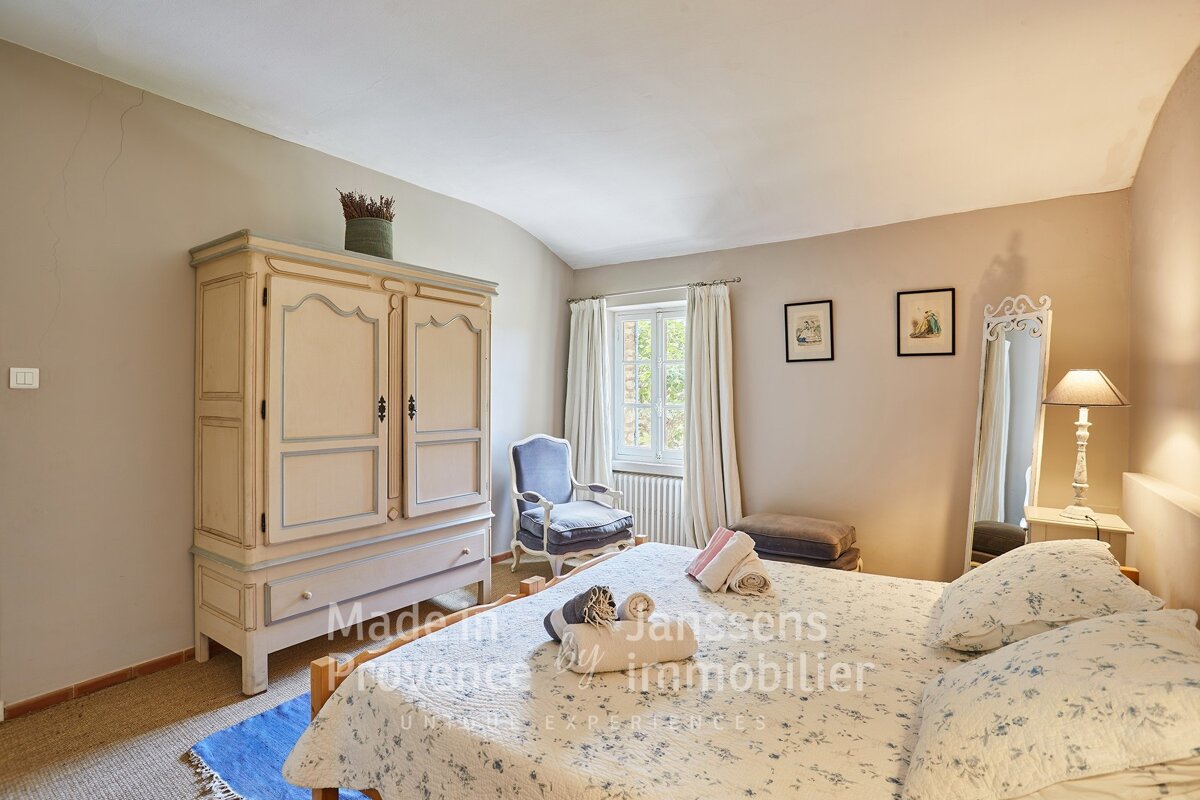 A bedroom with a bed and a wardrobe made in provence by janssens immobilier