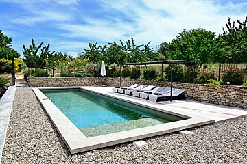 A large swimming pool surrounded by chairs and umbrellas