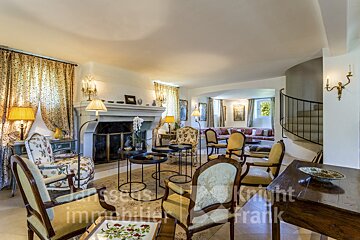 A living room with a fireplace and chairs and a sign that says knight immobiliers