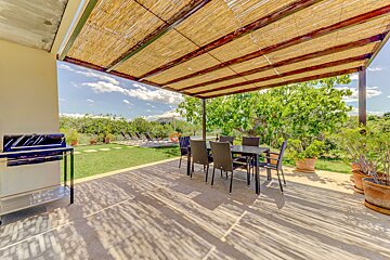 A patio with a table and chairs under a pergola