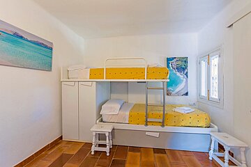 A bunk bed with yellow sheets is in a small room