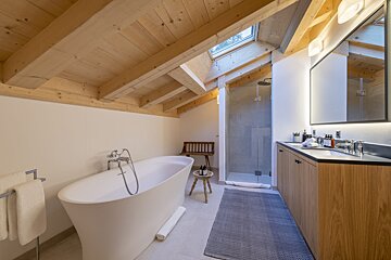 A bathroom with a bathtub and two sinks