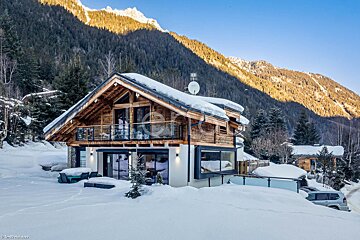 A snow covered house with a satellite dish on the roof