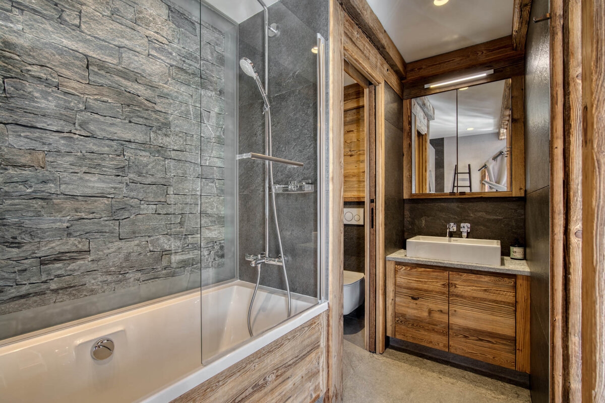 A bedroom with a bed with a bear on it