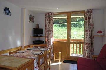 A living room with a table and chairs and a balcony