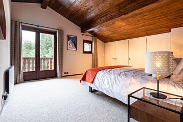 A bedroom with a bed and a lamp and a poster on the wall that says montagne