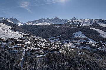 An aerial view of a ski resort with mountains in the background