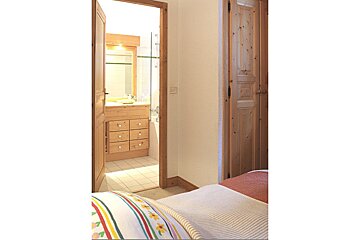 A bedroom with a wooden door leading to a bathroom