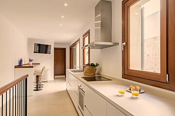A kitchen with two glasses of orange juice on the counter