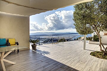 A patio with a view of the ocean and mountains