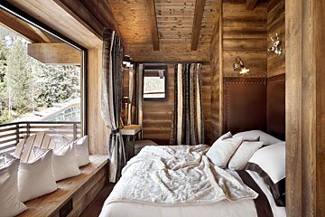 A wooden bedroom with a bed and a window