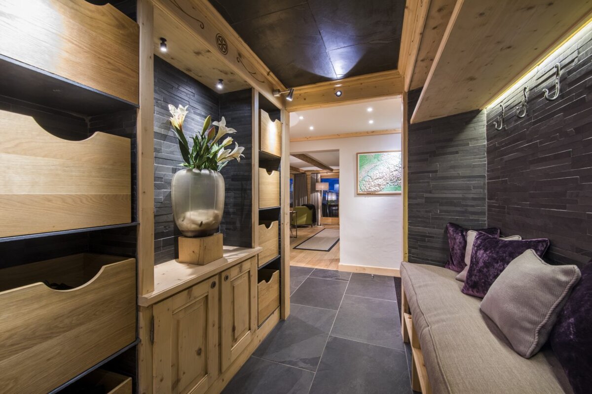 A hallway with a couch and a vase of flowers