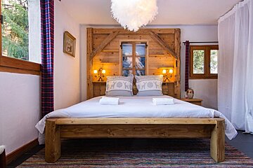A bedroom with a wooden bed and a window