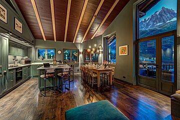 A kitchen and dining area with a mountain in the background