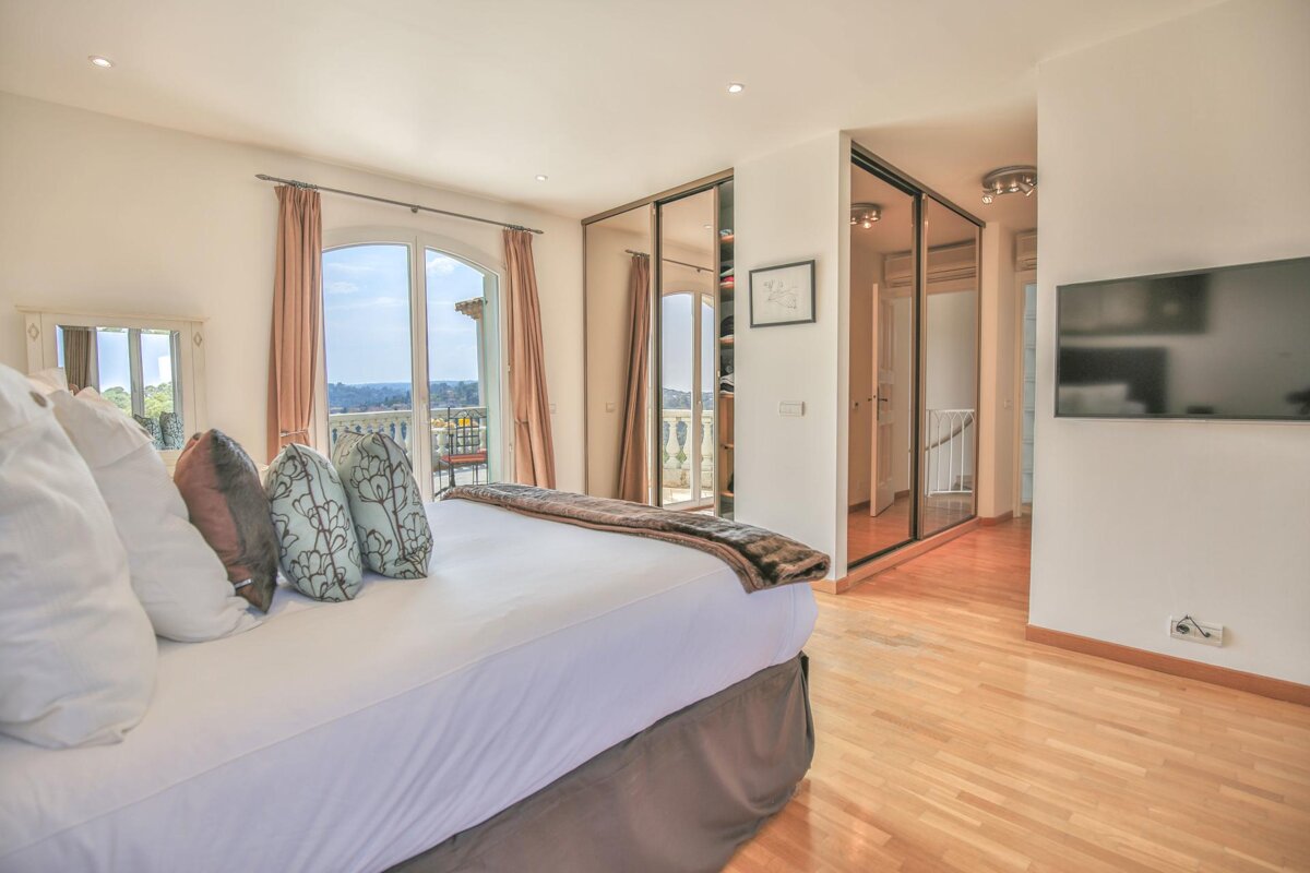 A bedroom with a large bed and a flat screen tv