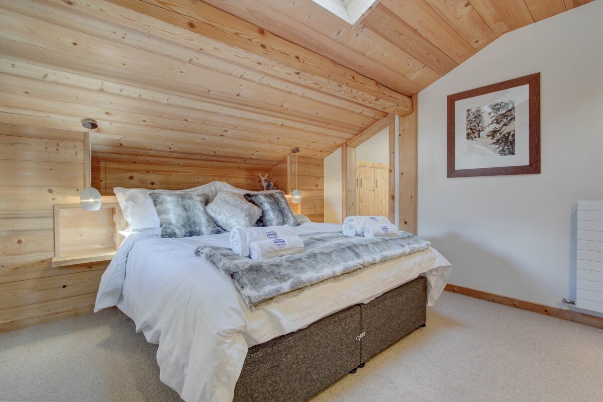 A bedroom with a bed and a picture on the wall