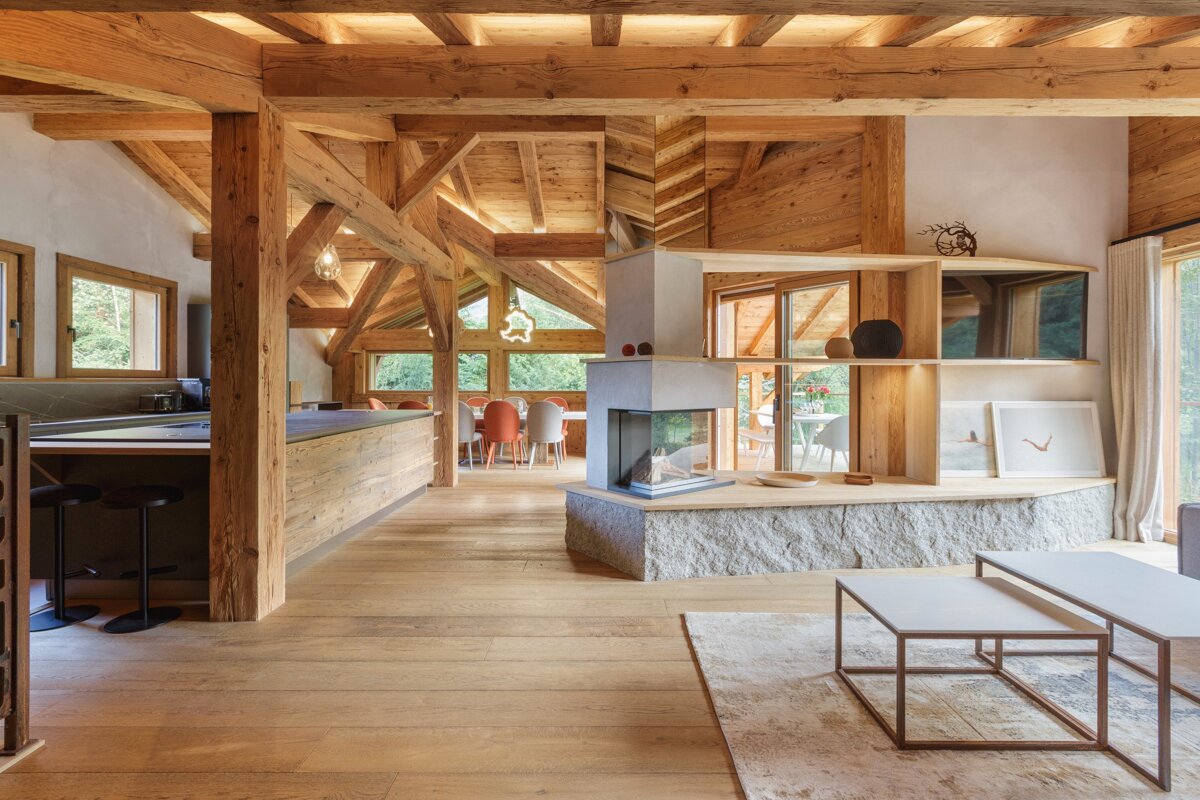 A living room with wooden beams and a fireplace