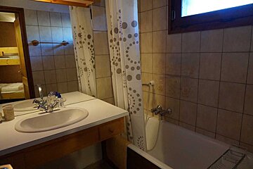 A bathroom with a white shower curtain and a sink