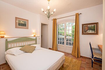 A bedroom with a bed and a painting on the wall
