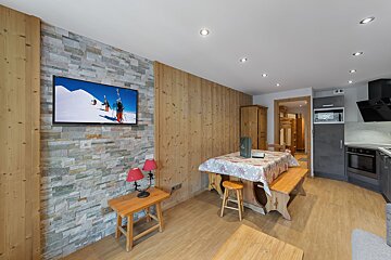 A flat screen tv shows skiers on a snowy mountain