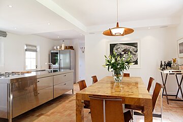 A dining room table with a vase of flowers on it